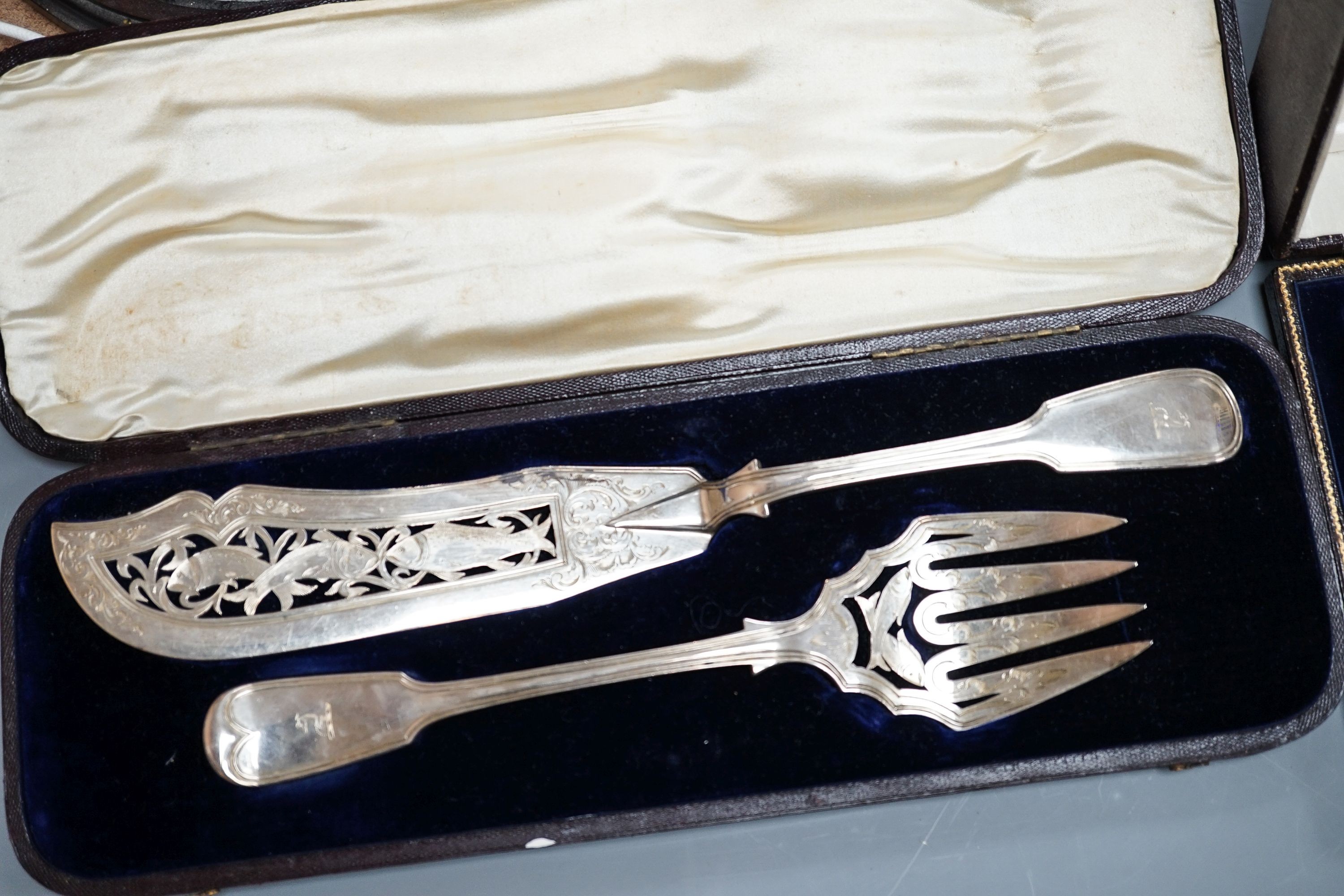 A cased pair of Victorian silver fish servers, London, 1856, together with a cased set of four George V pierced silver oval salts with cobalt blue glass liners (no spoons).